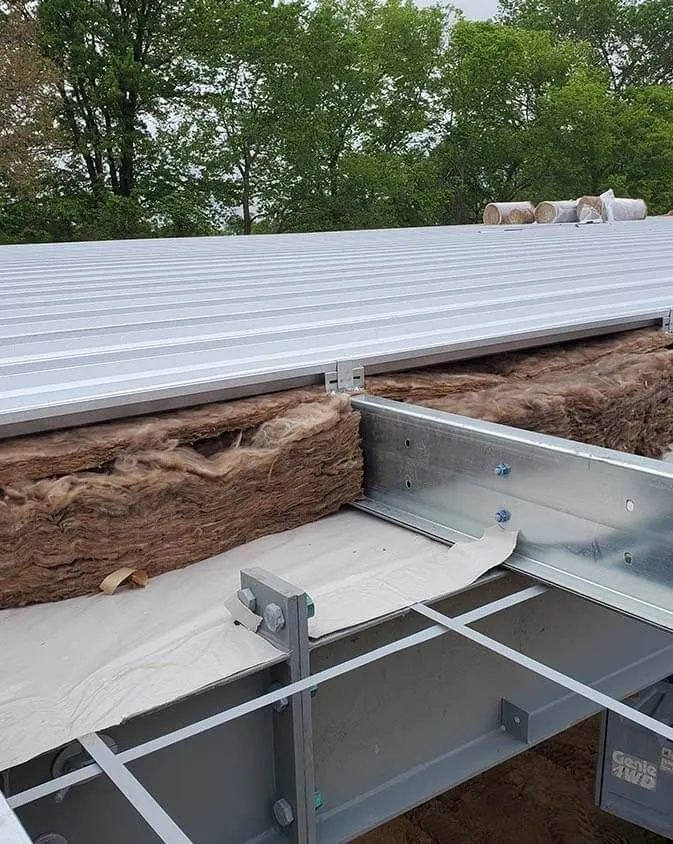 Metal roof construction with exposed insulation and framework.